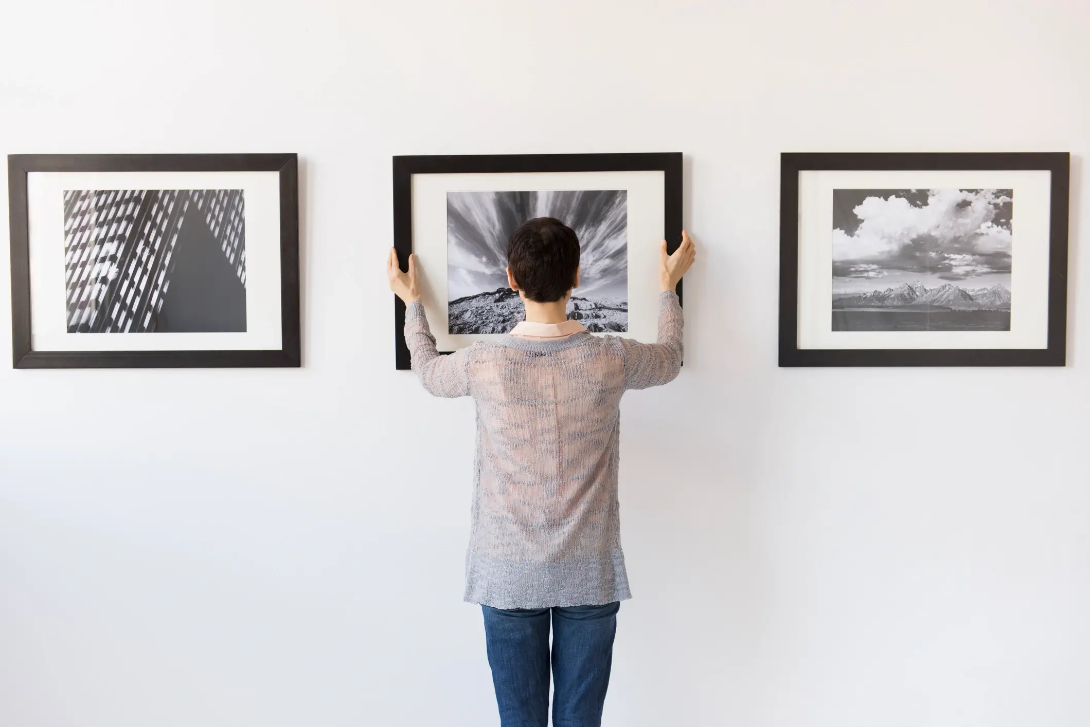 A person carefully handling a large art print